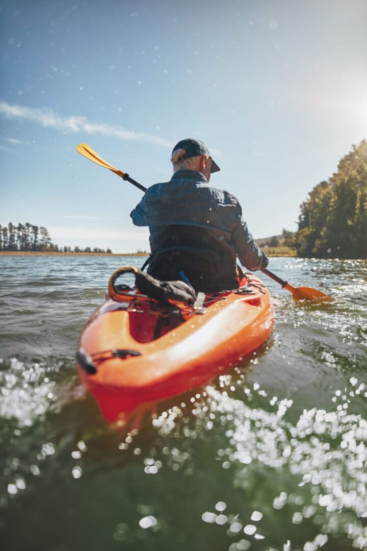 A man in a kayak is paddling through the water.
