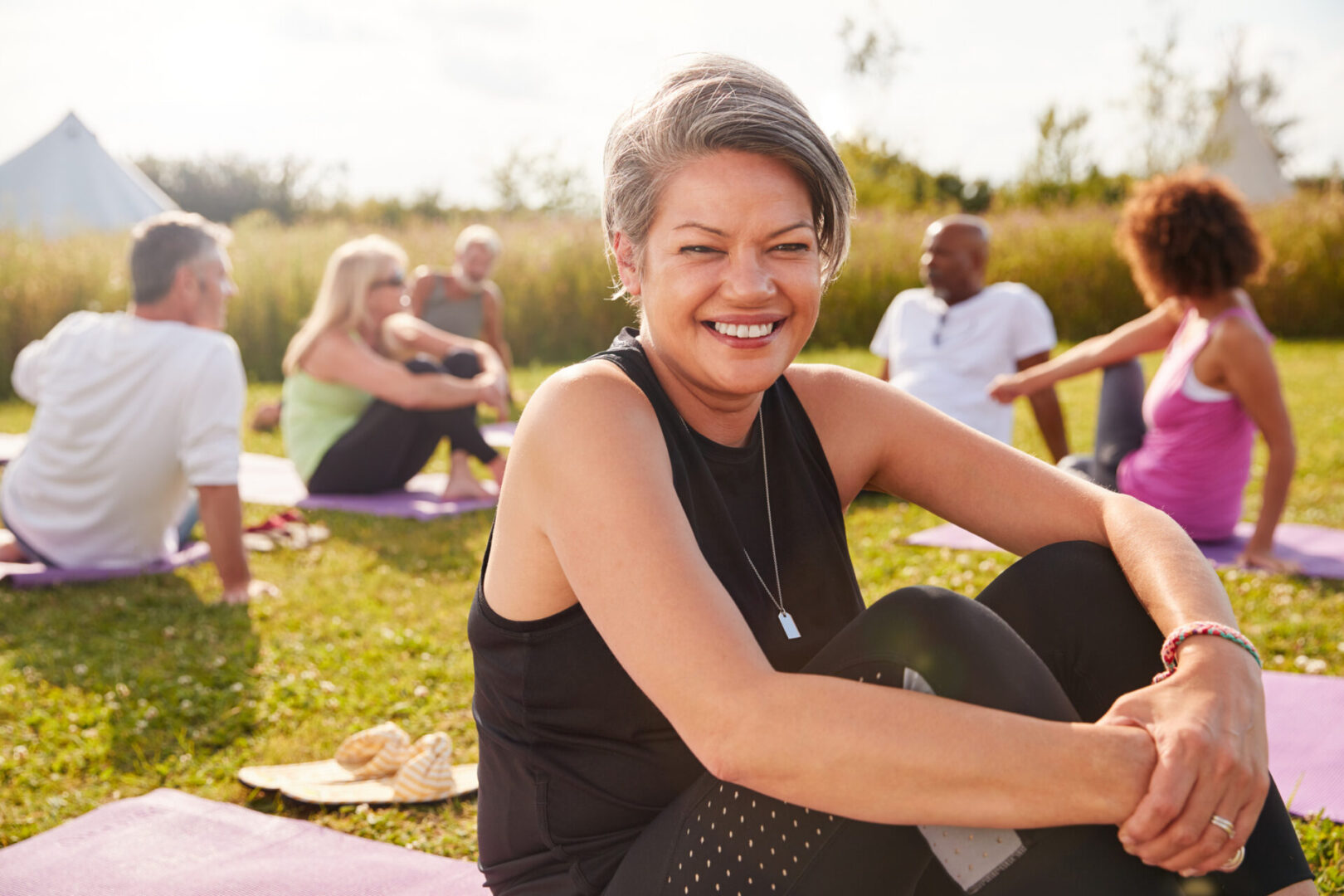 A woman sitting on the ground in front of other people.